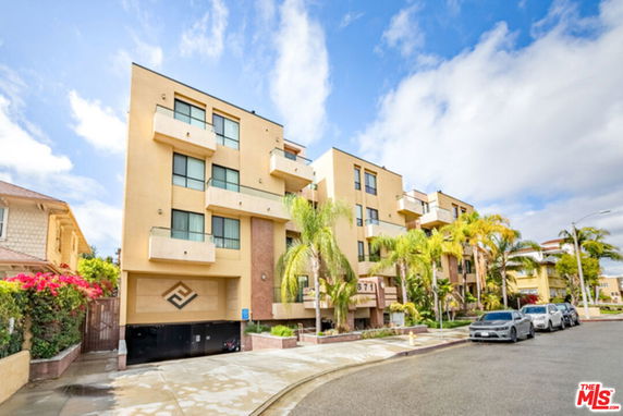 Front view of a multi-story residential building with balconies and large windows.