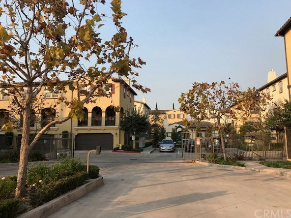 Front view of a multi-story residential building with gated entrance.