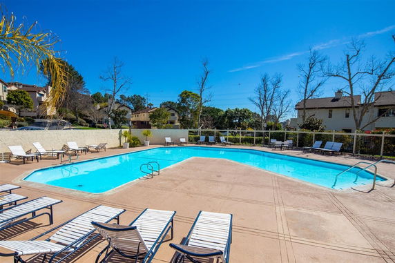 Outdoor swimming pool area with lounge chairs surrounding the pool.