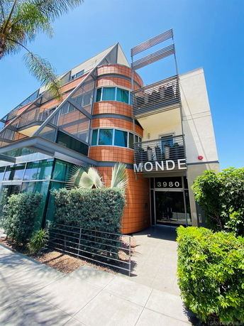 Front view of a modern multi-story building with a distinctive design and entrance.