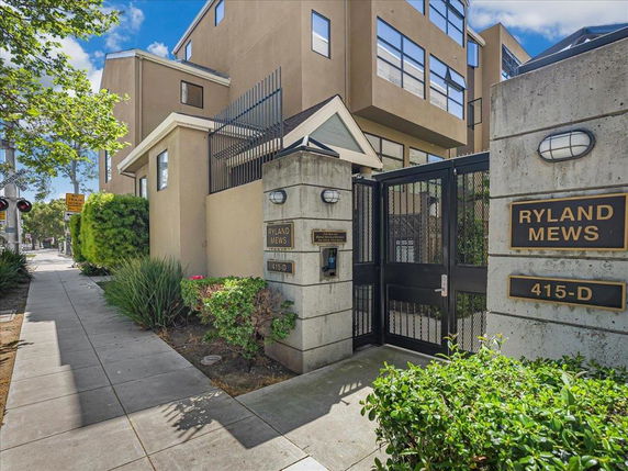 Front view of a multi-story building with gated entrance.