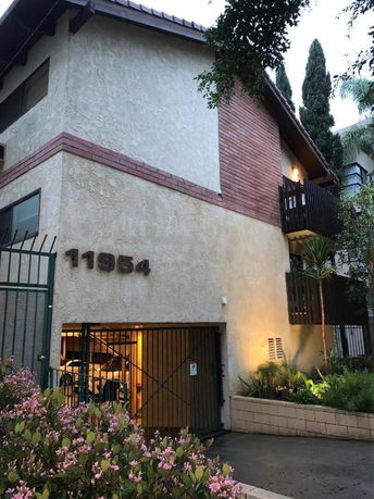 Front view of a multi-story building with gated entry.