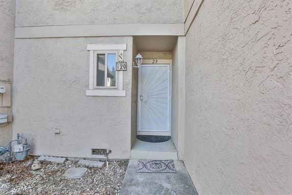 Front view of a house entrance with a decorative door and window.