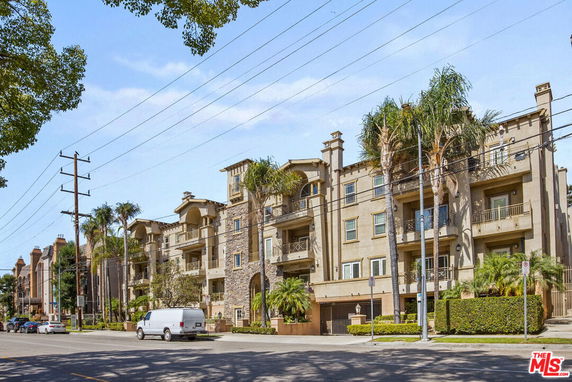 Front view of a multi-story apartment building with balconies.