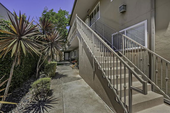Exterior view of a two-story building with an external staircase.