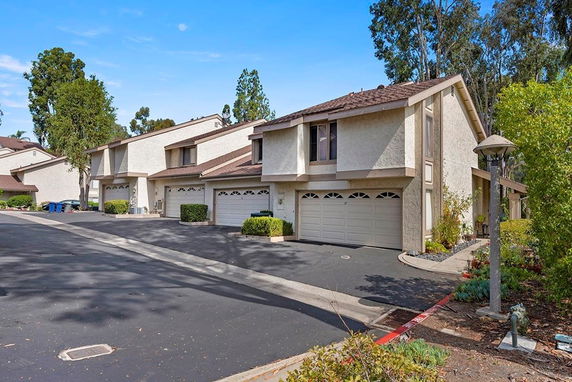 Front view of townhouses with double garages and sloped roofs.