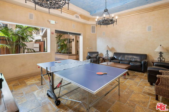 Indoor area with a ping pong table and seating, suitable for recreation activities.