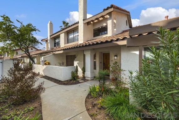 Front view of a two-story house with a walkway and garden.