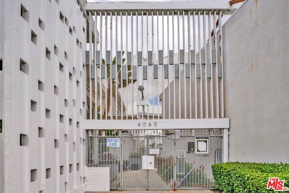 Front view of a building with a gated entrance and vertical slats.