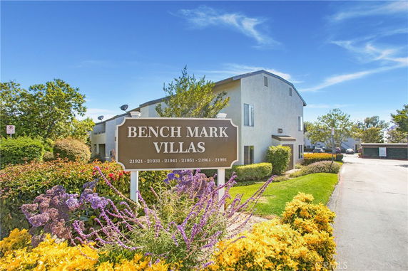 Front view of a multi-story villa apartment building with a sign in front.