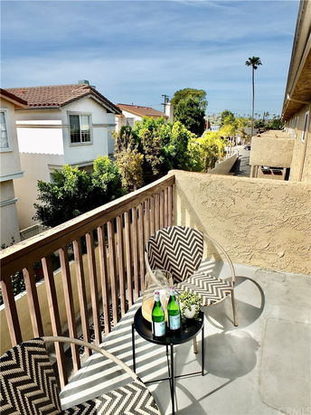 Balcony view overlooking residential area with nearby houses and trees.