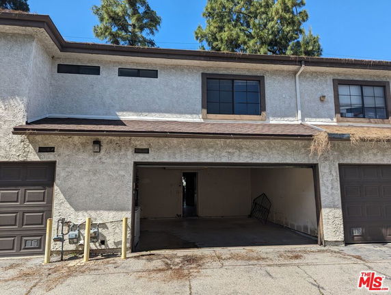 Front view of a two-story building with an open garage.