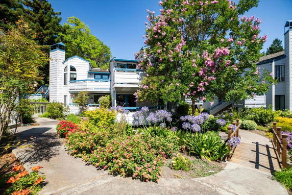 Front view of a house with a two-story structure featuring a balcony and garden pathway.