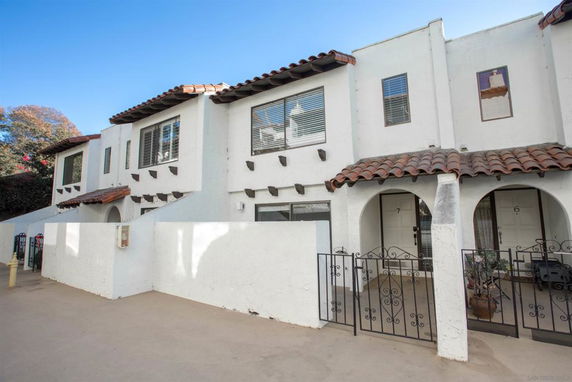 Front view of a two-story building with white exterior and tile roofing.