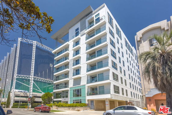 Front view of a multi-story residential building with balconies.