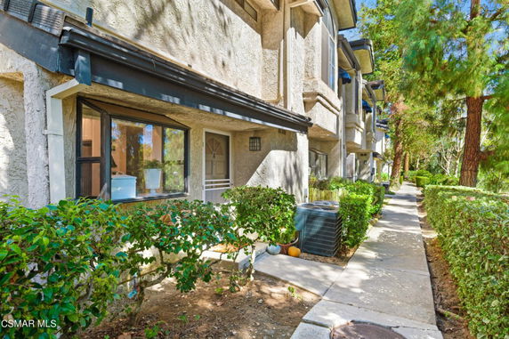 Front view of a multi-story building with a pathway and greenery.