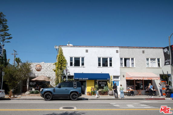Front view of a commercial building with shops and cafes.