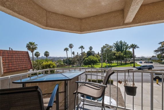 View of surrounding areas from a balcony with outdoor furniture.
