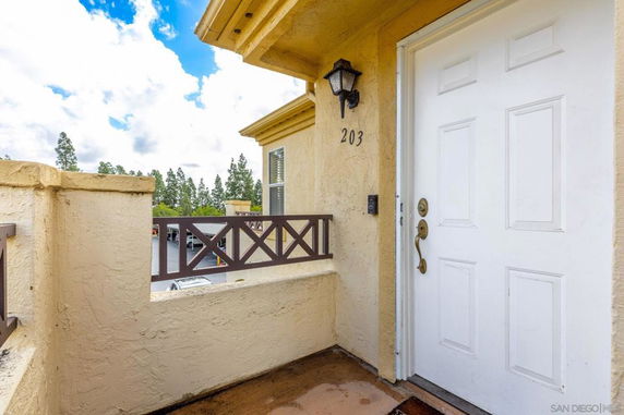 Entryway of a house with an outdoor view of trees and parked cars.