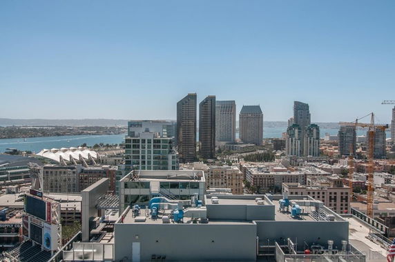 Panoramic view of a cityscape with high-rise buildings and a waterfront.