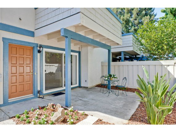 Front view of a two-story house with a small patio area.