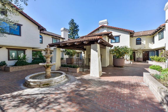 Front view of a multi-story building with courtyard and fountain.
