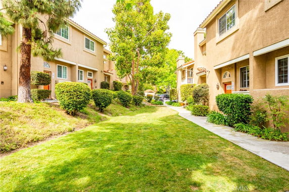 View of a residential area with multiple two-story houses and landscaped walkways.