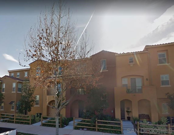 Front view of a multi-story residential building with arches and balconies.
