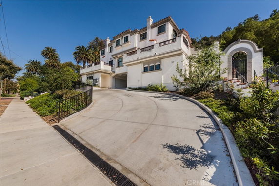 Front view of a multi-story house with a large driveway.