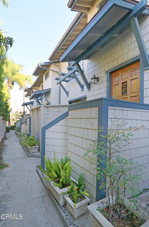 Front view of townhouses with shingled exterior and wooden doors.