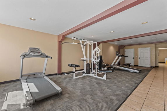 Indoor gym area with exercise equipment including treadmills and a weight machine.
