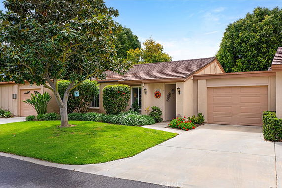 Front view of a single-story house with an attached garage and a small garden.
