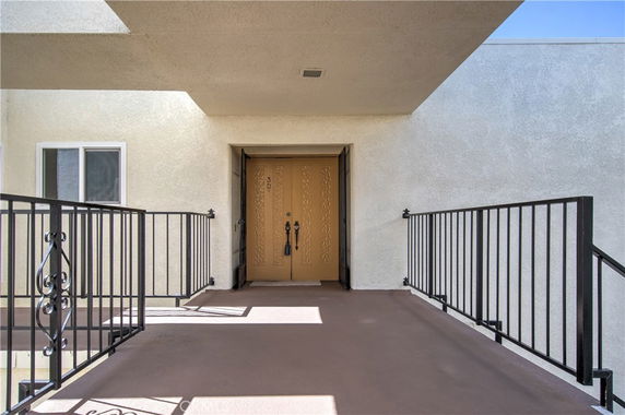 Front view of a building entry with double doors and railing.