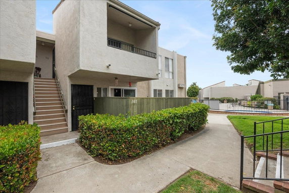 Front view of a multi-story residential building with an exterior staircase.