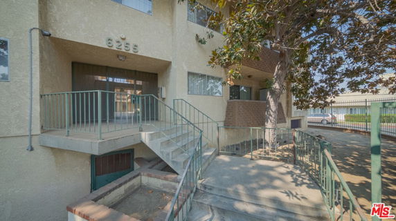Front view of a multi-story building with entrance and stairs.