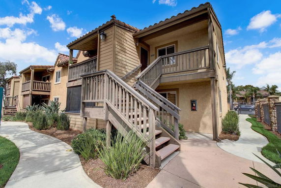 Front view of a two-story residential building with exterior stairs and balconies.