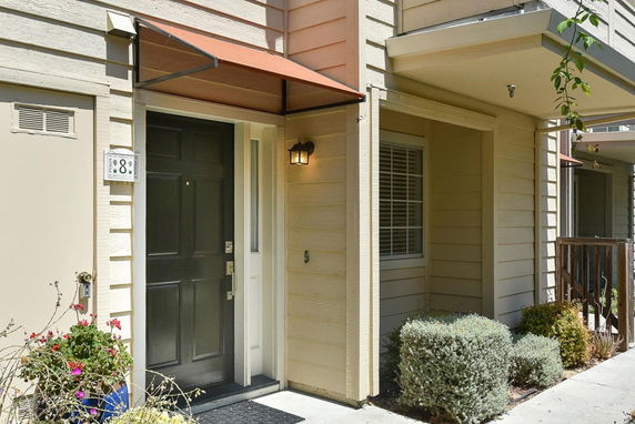 Front view of a house with a black door and small porch area.