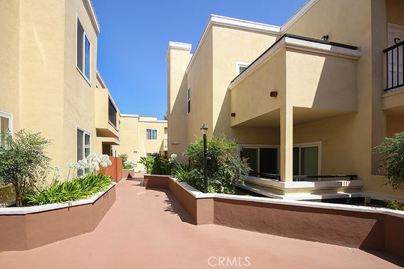 Front view of a multi-story building with beige walls and large windows.