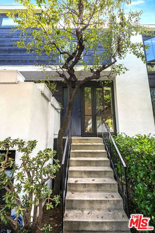 Front view of a house with a staircase leading to the entrance.
