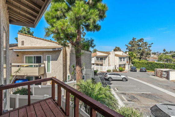 View of a residential parking area with several cars parked at an apartment complex.