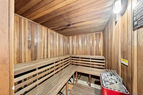 Interior view of a wooden sauna with benches and a heater.