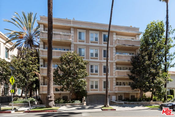 Front view of a multi-story apartment building with balconies.