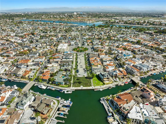 Aerial panoramic view of a residential neighborhood with waterways and densely packed houses.
