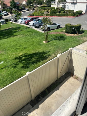 View of parked cars in a parking area adjacent to green lawns.