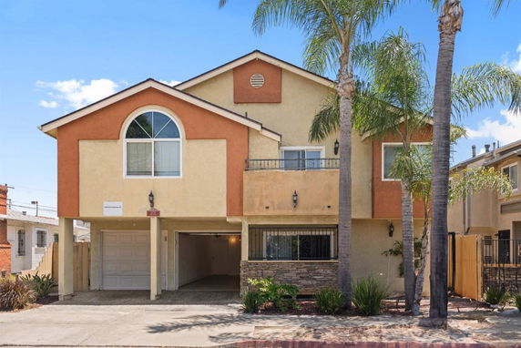 Front view of a two-story house with a garage and a balcony.