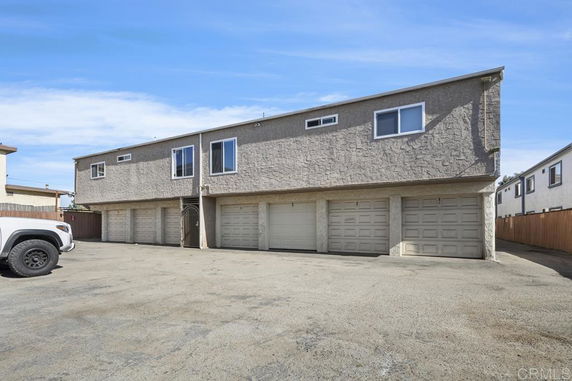 Front view of a two-story building with multiple garages.