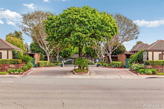 Front view of residential buildings with gable roofs and landscaped entrance.