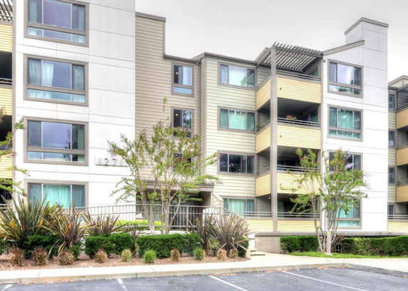 Front view of a multi-story apartment building with balconies.
