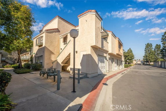 Front view of a multi-story residential building with garage and exterior stairs.