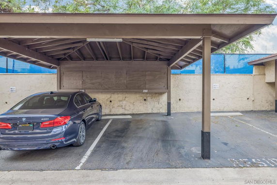 Covered outdoor parking area with a car.